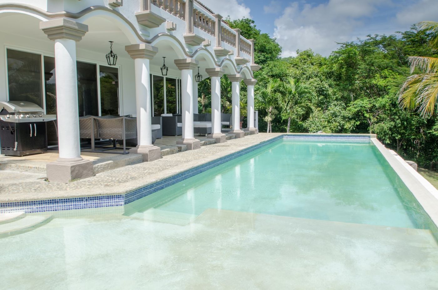 Overview of Casa Guacalito’s infinity pool from the far end, featuring column arches.